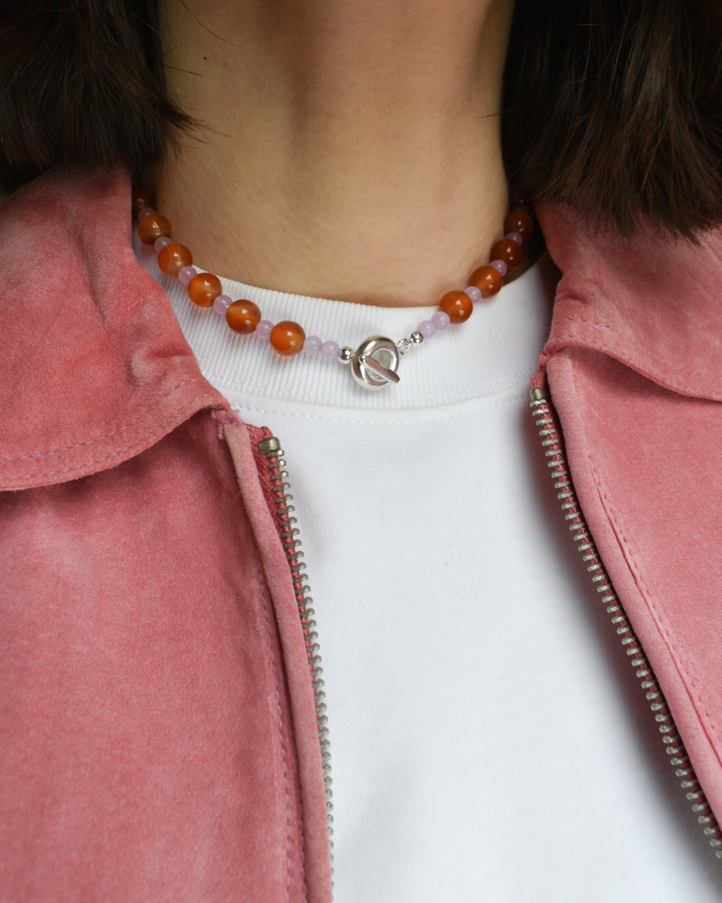 beaded necklace made of colourful stones and solid recycled silver doughnut toggle clasp. the necklace is orange and lilac purple with carnelian and lilac dyed jade.