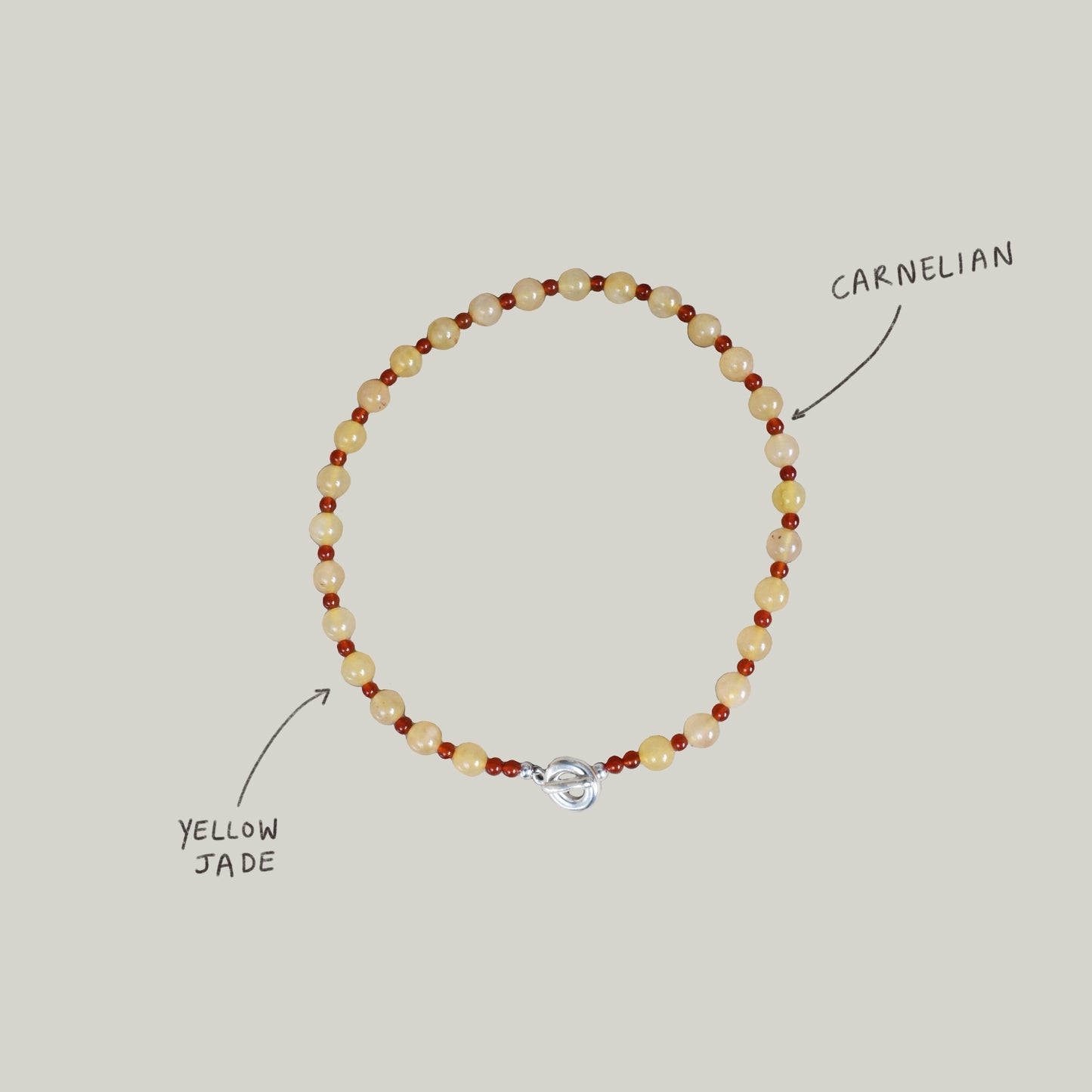 peach melba round smooth colourful beaded braclelet with red carnelian and yellow jade. finished with solid silver doughnut shaped clasp.