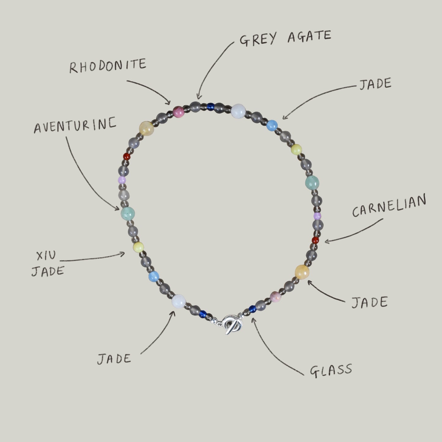 a colourful beaded braclet in a neutral brown grey base with colored stone and glass beads. blue jade, agate, carnelian, aventurine. finished with solid recycled silver doughnut toggle clasp.