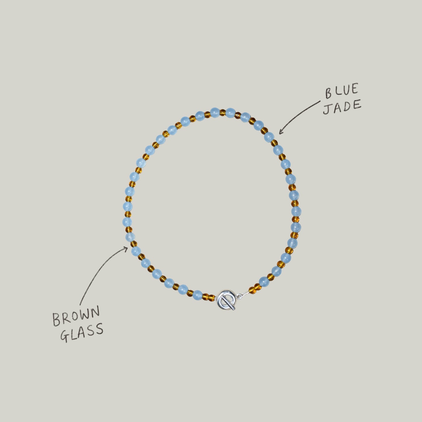 colourful beaded necklace in brown glass beads and baby blue jade semi precious stones. finished with hand carved solid recycled silver doughnut clasps.