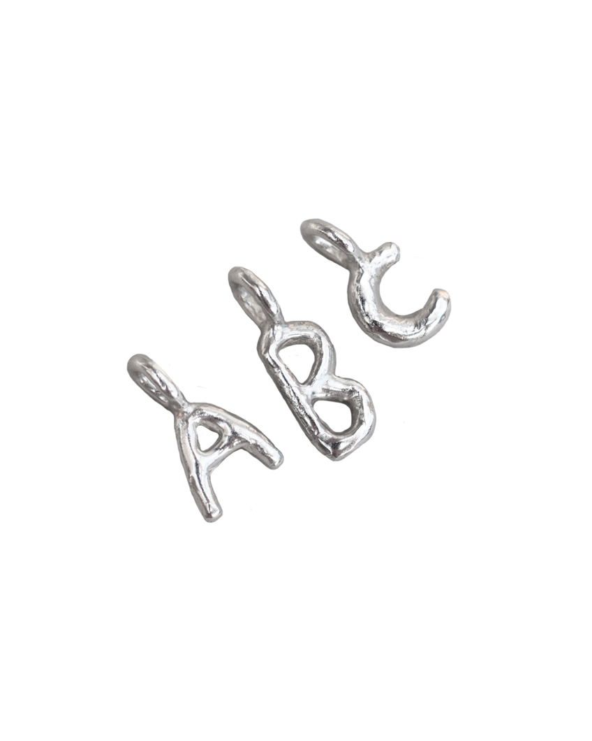 recycled silver hand moulded wobbly alphabet initial charms with organic texture 
