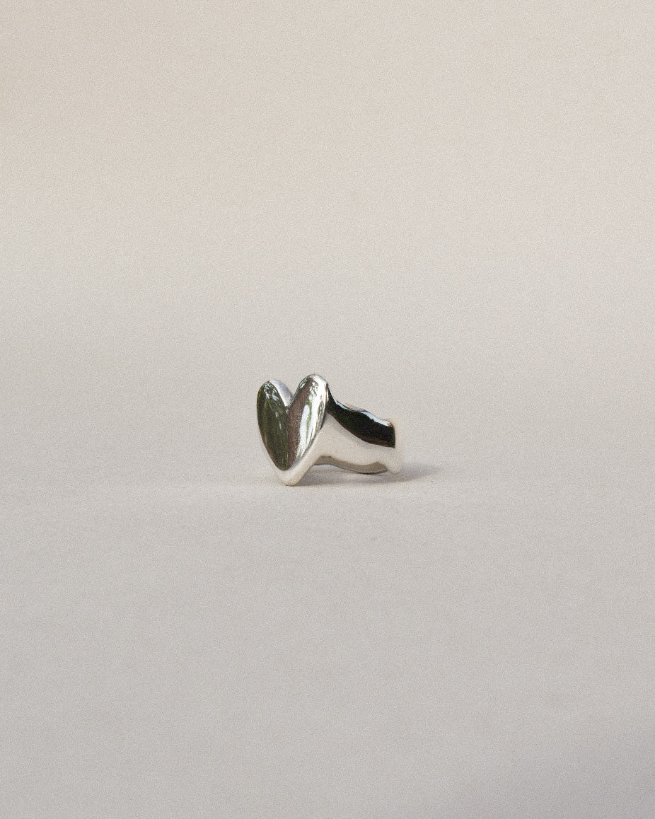 hand carved heart shaped signet ring with waved band and organic wobbly shape. shiny solid recycled silver. eco metal.