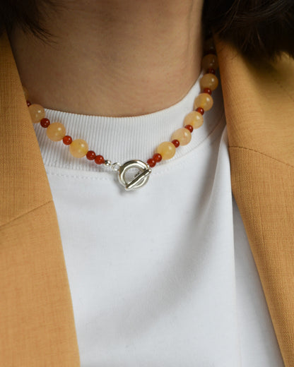 peach melba round smooth colourful beaded necklace with red carnelian and yellow jade. finished with solid silver doughnut shaped clasp.