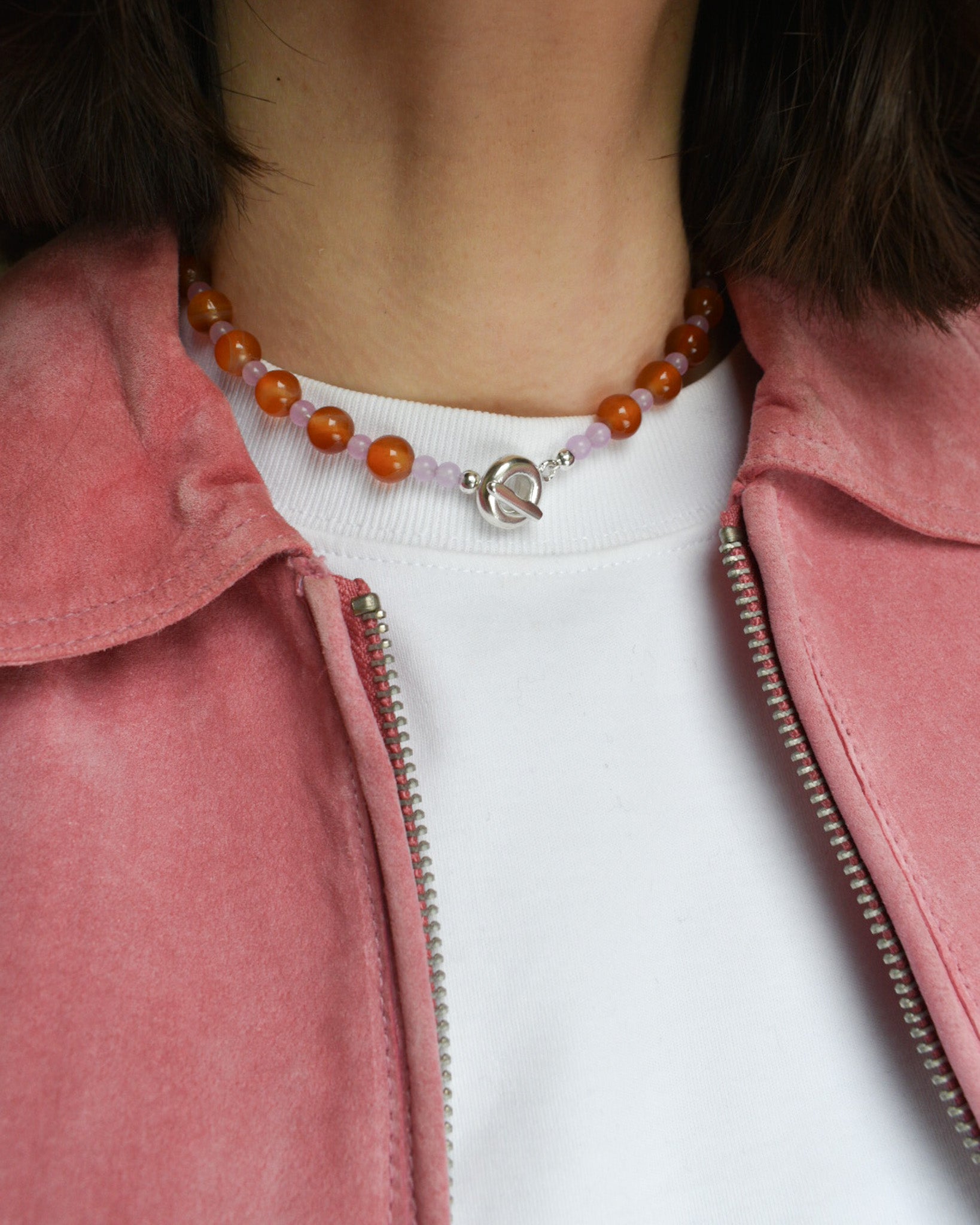 beaded necklace made of colourful stones and solid recycled silver doughnut toggle clasp. the necklace is orange and lilac purple with carnelian and lilac dyed jade.