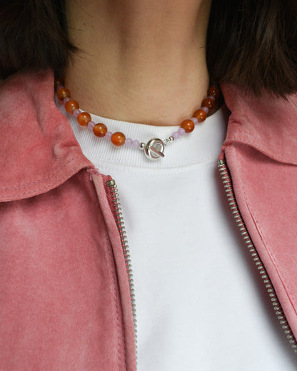 beaded necklace made of colourful stones and solid recycled silver doughnut toggle clasp. the necklace is orange and lilac purple with carnelian and lilac dyed jade.