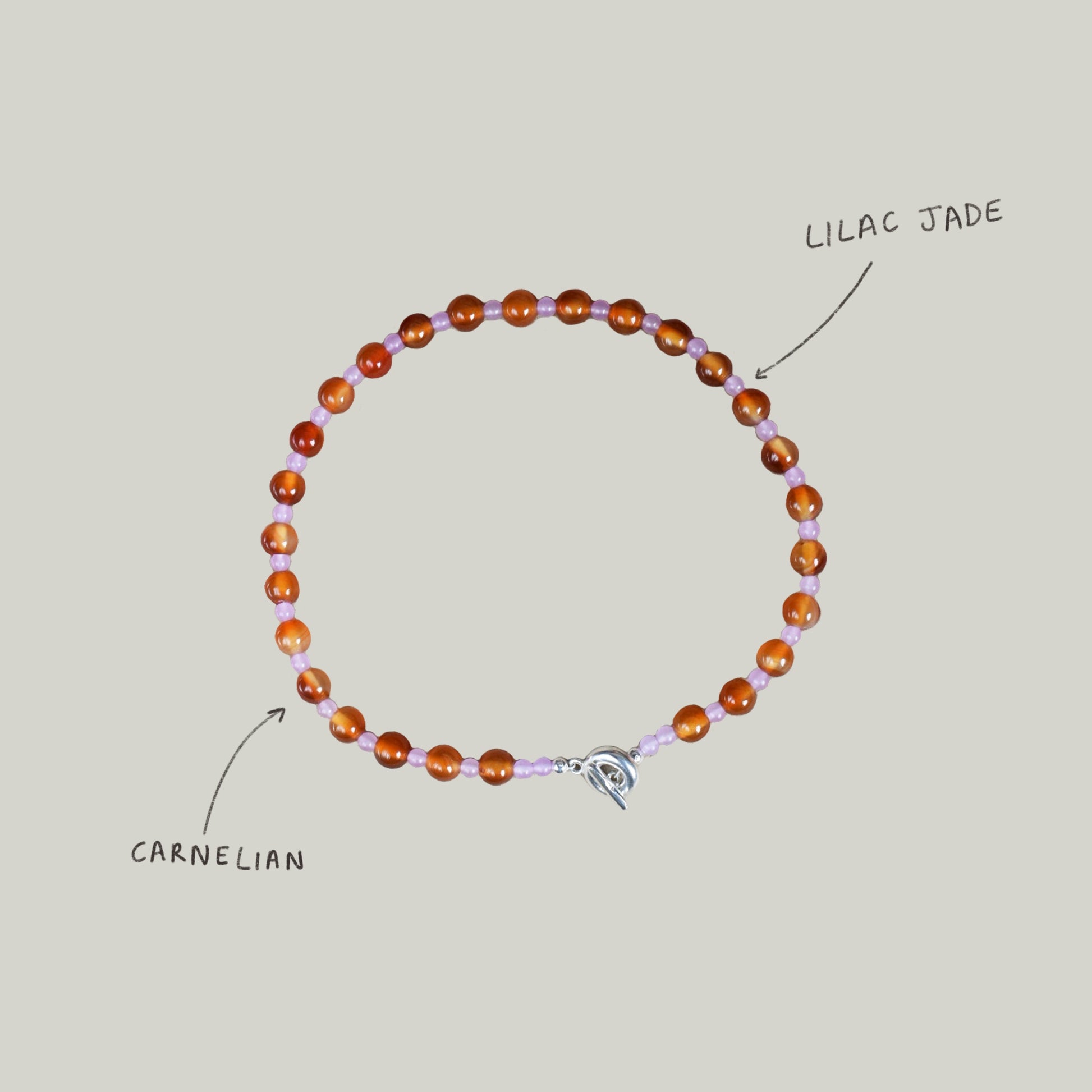 beaded necklace made of colourful stones and solid recycled silver doughnut toggle clasp. the necklace is orange and lilac purple with carnelian and lilac dyed jade.