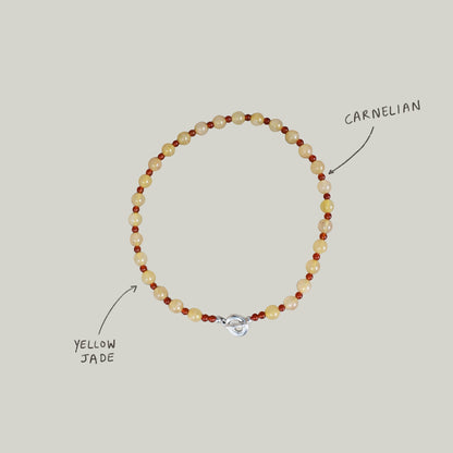 peach melba round smooth colourful beaded braclelet with red carnelian and yellow jade. finished with solid silver doughnut shaped clasp.