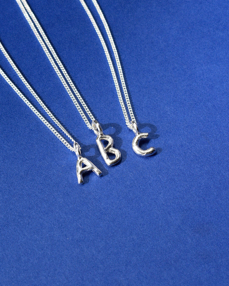recycled silver hand moulded wobbly alphabet initial charms with organic texture