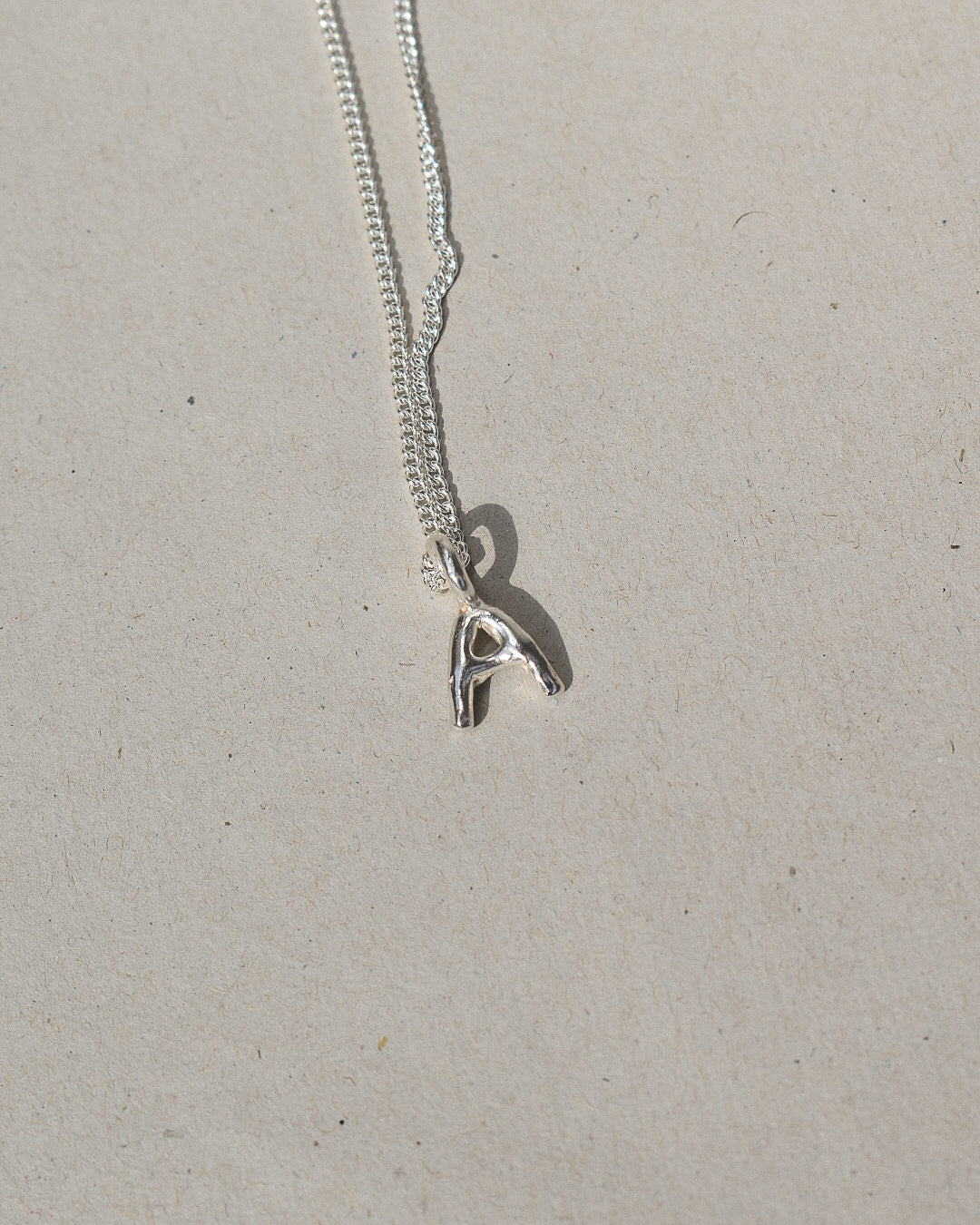 recycled silver hand moulded wobbly alphabet initial charms with organic texture