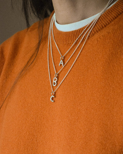 three layered silver chains with recycled silver hand moulded wobbly alphabet initial charms with organic texture